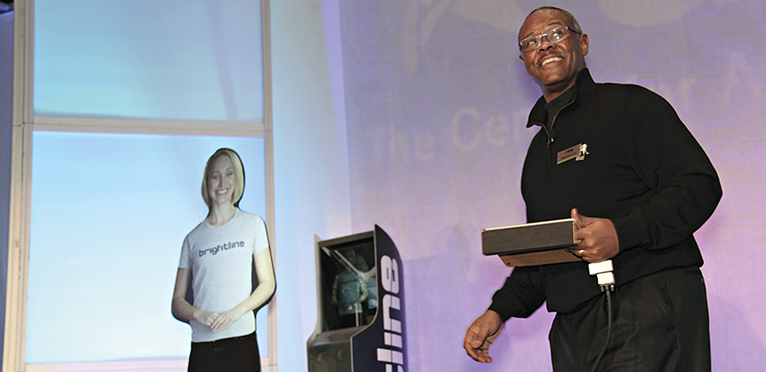 ASAE CIO Reggie Henry, CAE, interacts with a virtual booth attendant at a technology conference. Credit: ASAE