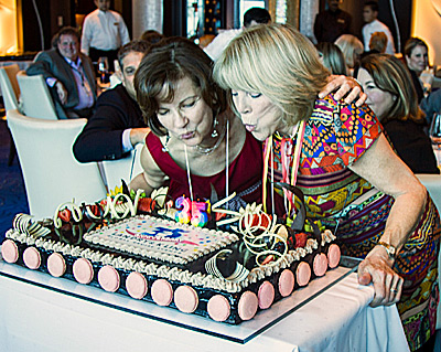 Joyce Landry (left) and Jo Kling blow out the candles on their 35th Anniversary cake.