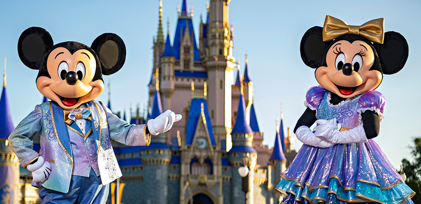 The iconic Mickey Mouse and Minnie Mouse characters stand in front of Cinderella Castle in Magic Kingdom Park.