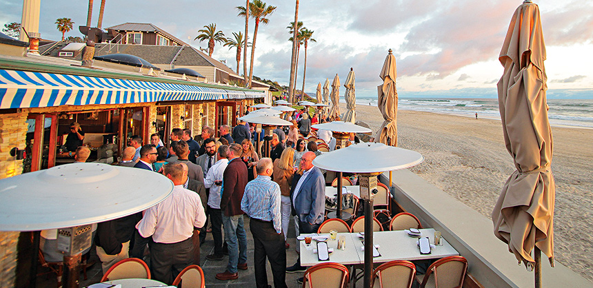 Team members connect during a sunset beach cocktail reception at a meeting in San Diego, California. Courtesy of Dave Minnelli