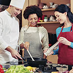 happy friends and chef cook cooking in kitchen